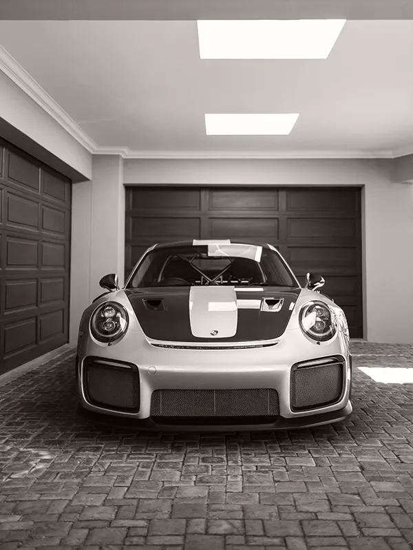 Porsche 911 GT2 RS positioned front-facing inside a private garage, showing the car as a central presence rather than simple storage.